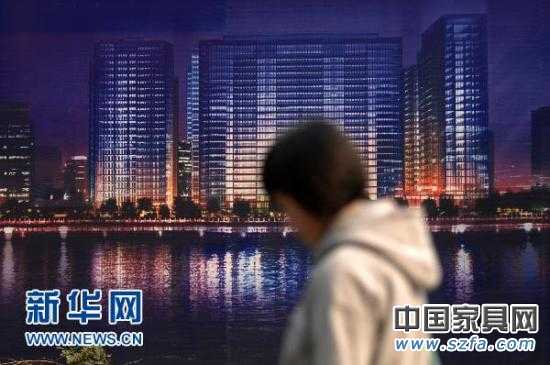 一位市民從杭州市區(qū)的一處商業(yè)樓盤廣告牌前走過（2010年11月4日攝）。新華社記者 黃宗治 攝 