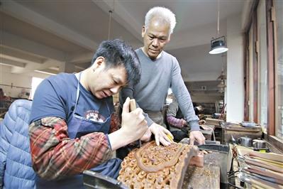 中國僑網(wǎng)胡敏強(qiáng)（右）在指導(dǎo)年輕人雕刻紅木。 